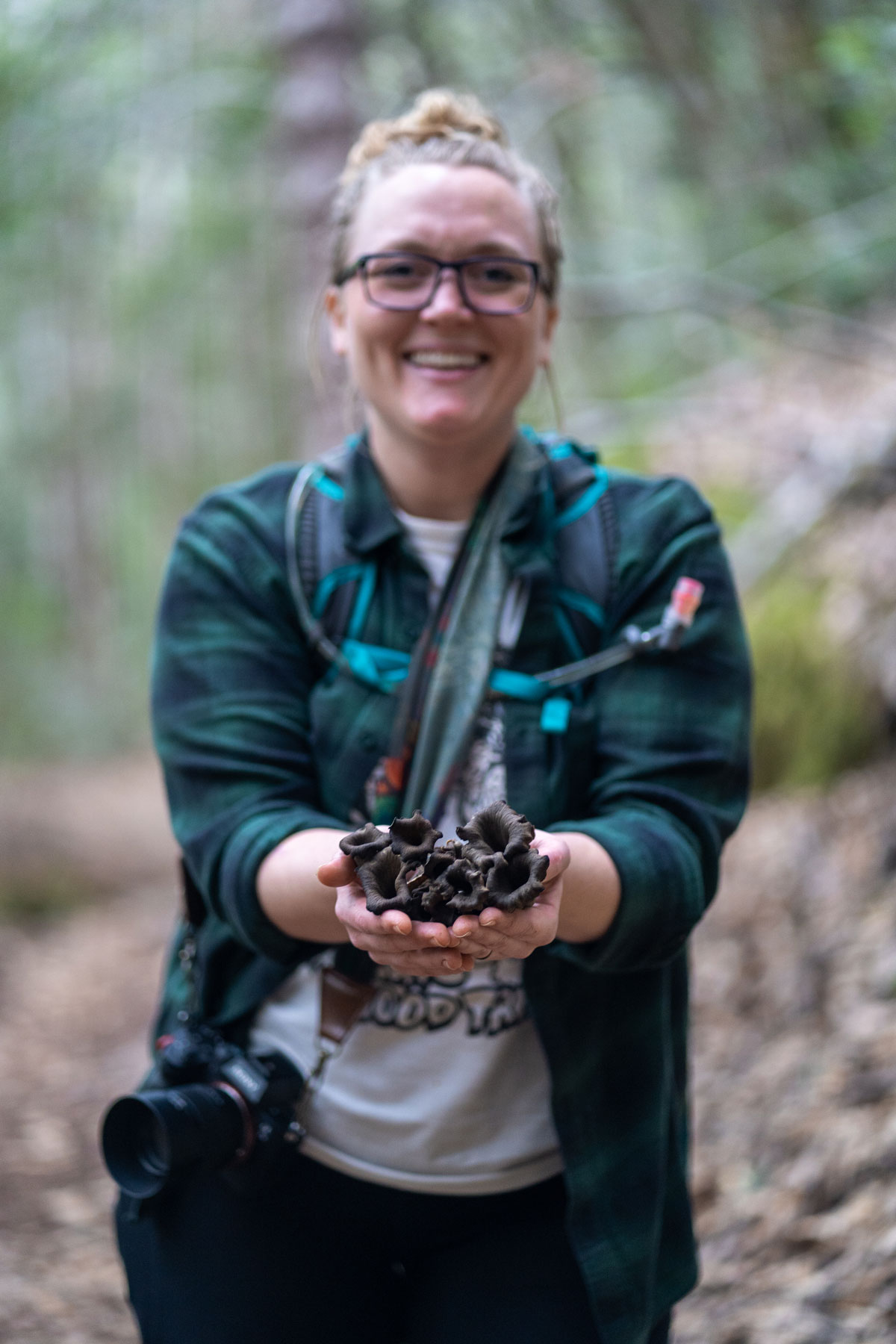 Grace showing off a handful of Black Trumpet mushrooms foraged on our hike.