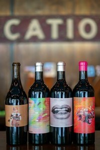 A lineup of Tank Garage Winery bottles with vibrant and bold labels.